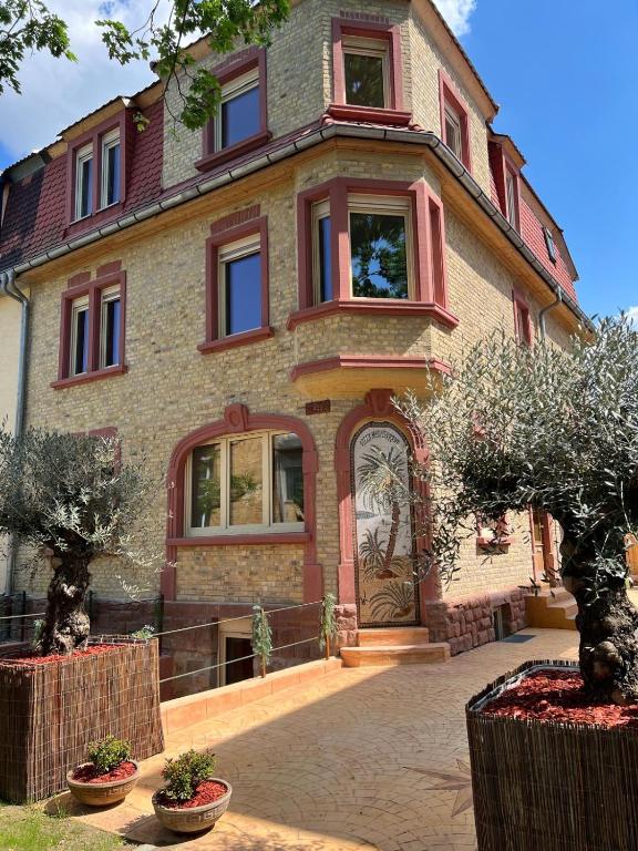 a large brick house with trees in front of it at Villa Mediterrane - Apartment Bologne in Frankenthal