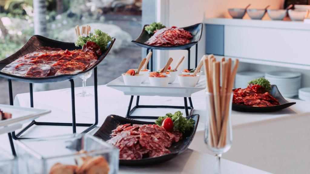 a buffet with several plates of food on a table at Labranda Marieta & Spa - Adults Only in Playa del Ingles