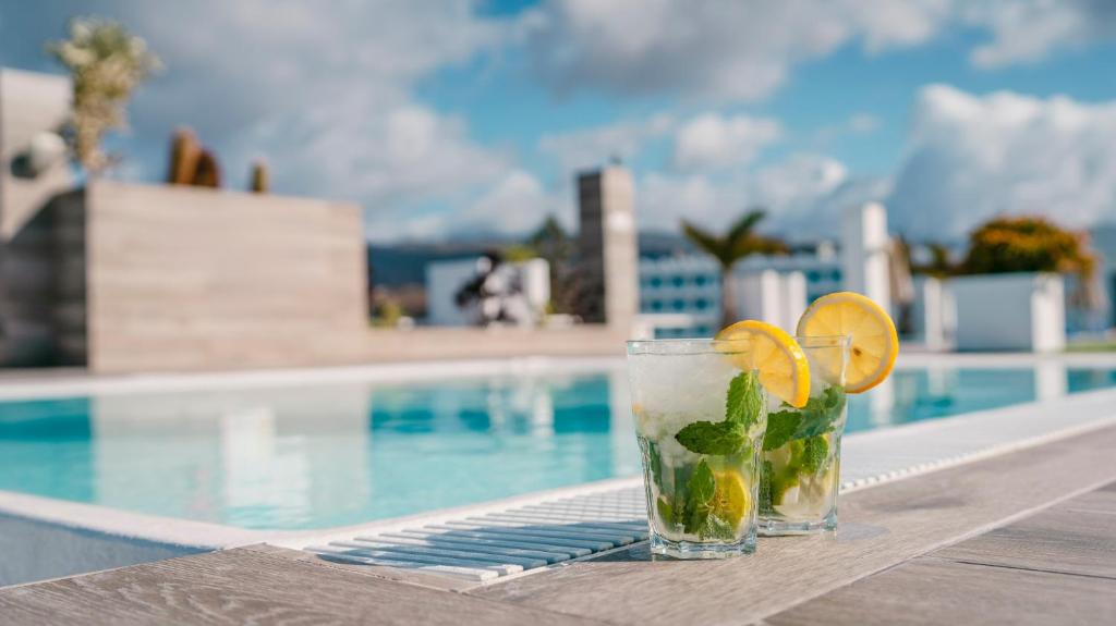 a drink on a table next to a swimming pool at Labranda Marieta & Spa - Adults Only in Playa del Ingles