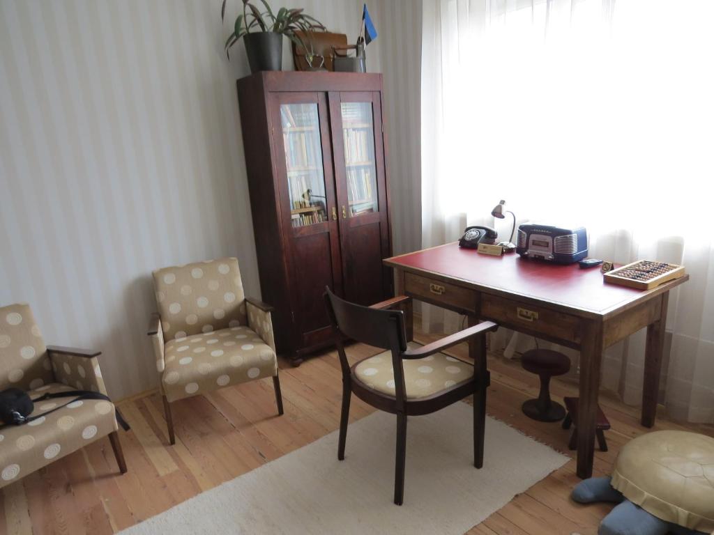 una oficina con escritorio de madera, silla y mesa en Perepuhkus Apartment, en Pärnu