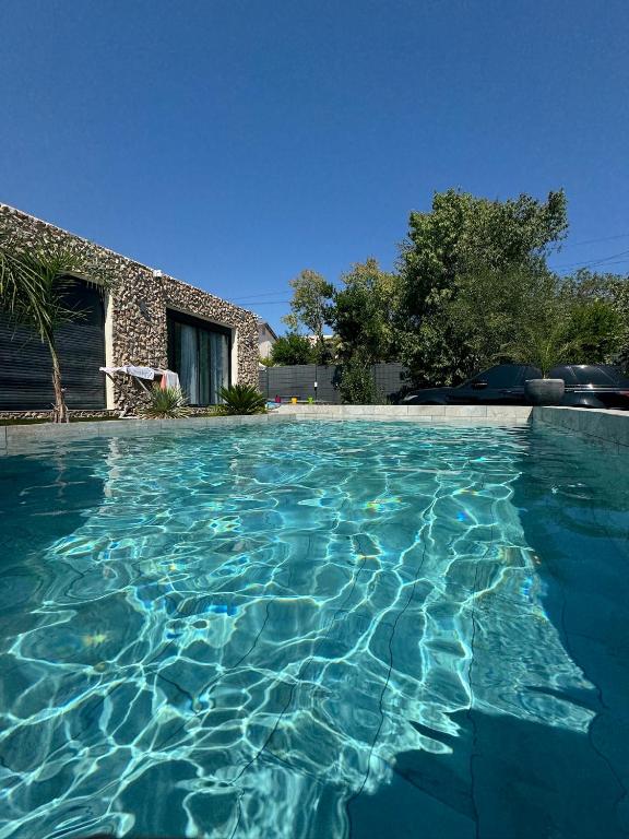 une piscine avec de l'eau bleue devant une maison dans l'établissement Havre de Paix avec Villa Prestige Cannes Luxe, Piscine Chauffée, Alarme, Caméras Parking privée, au Cannet