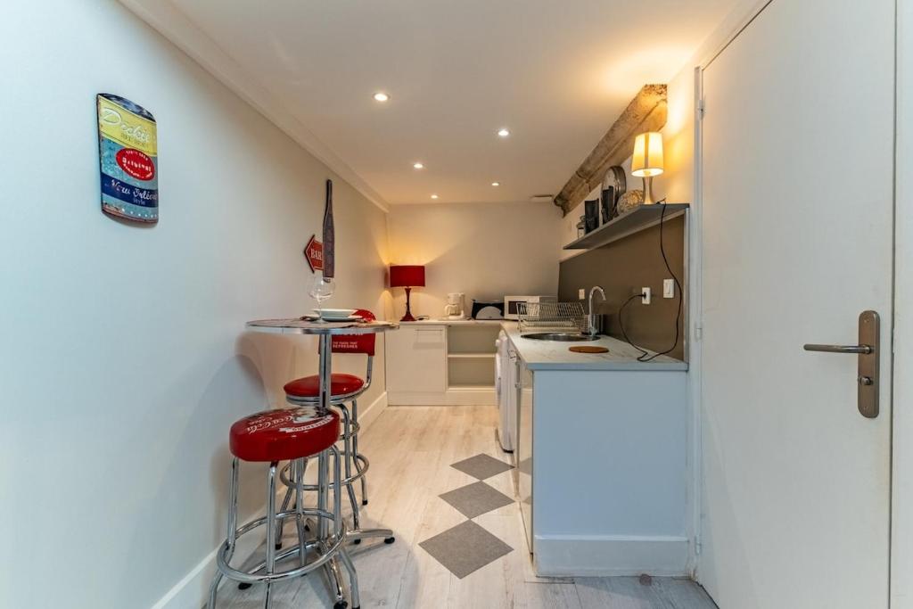 une cuisine avec un comptoir et des tabourets dans une pièce dans l'établissement Le Nid - Duplex, à Dijon