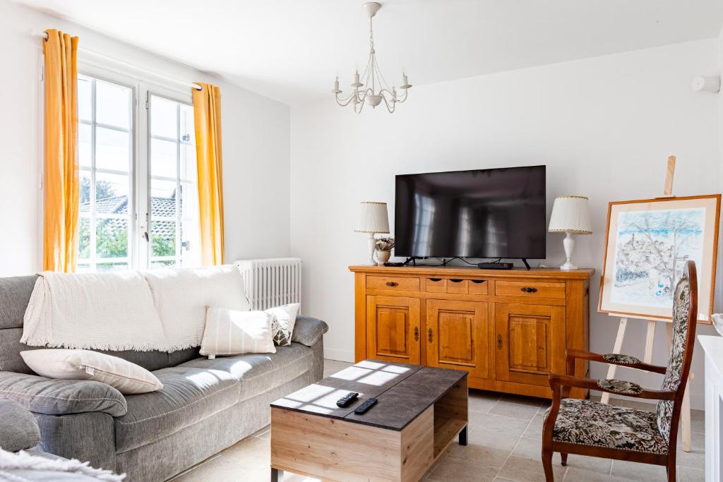 un salon avec un canapé et une télévision dans l'établissement La parenthèse enchantée, à Coulounieix-Chamiers