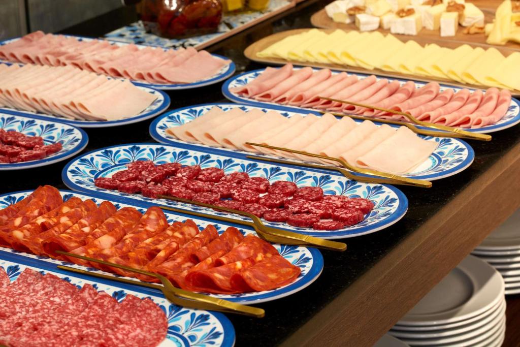 A buffet counter displaying sliced meats, cured meats and cheeses.