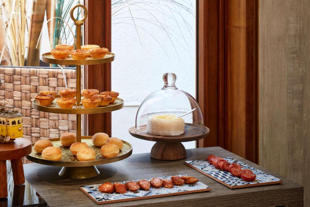 A styled breakfast display of pastries, bread rolls, cheese and cured meats.