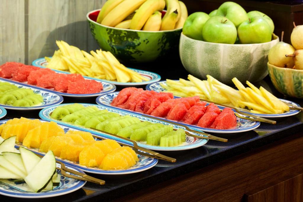 A colourful fruit buffet with sliced melons, pineapple, kiwi and whole fruit.