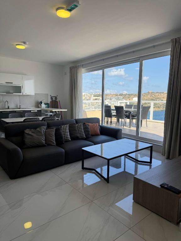 a living room with a couch and a table at 3 Bedrm Penthouse Amazing Views in St Paul's Bay