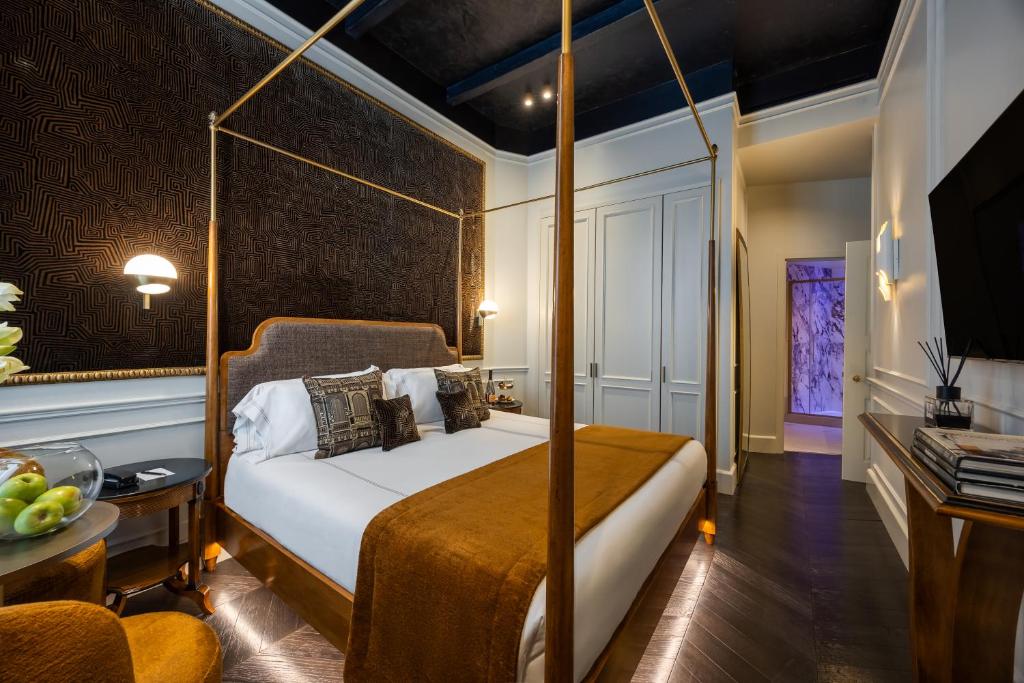 a bedroom with a canopy bed with a table at HT6 Maison in Rome