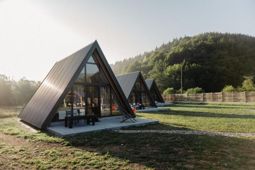 a house with a triangular roof on a grass field at Jahorinski kutak in Jahorina