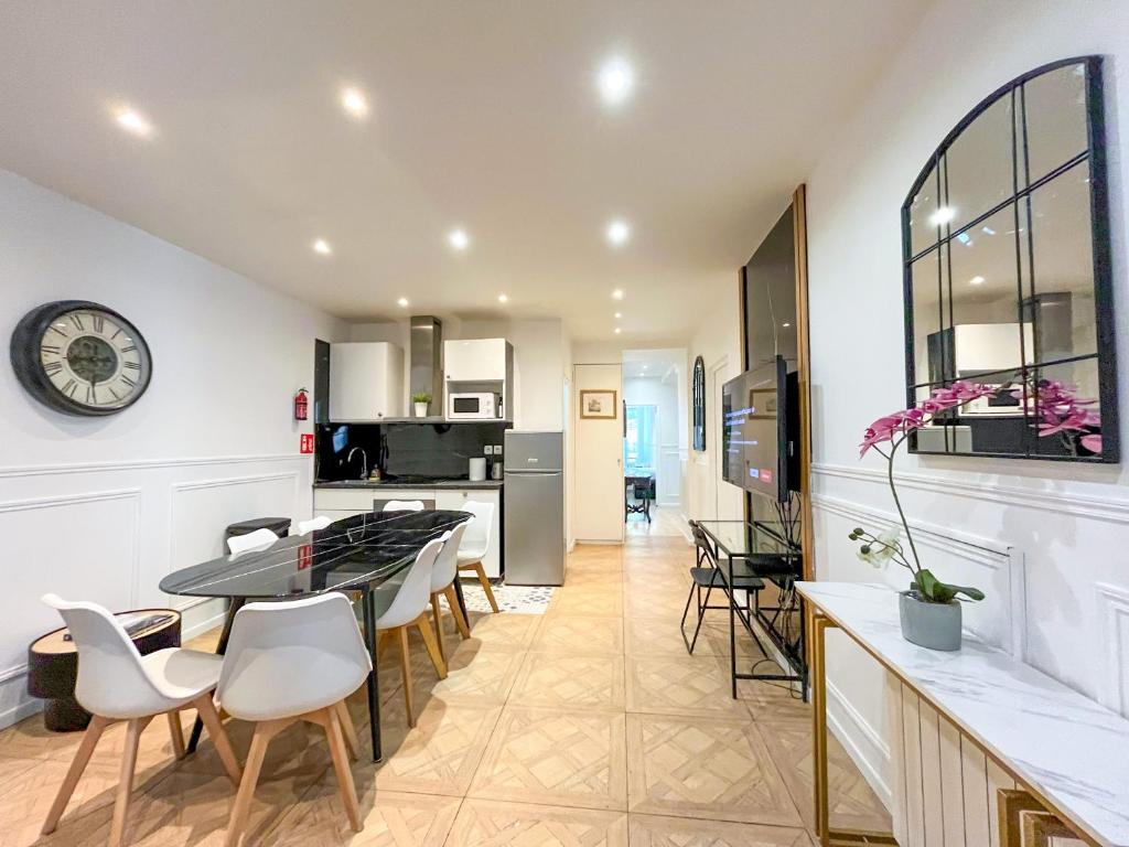 une cuisine et une salle à manger avec une table et des chaises dans l'établissement Urban Flat 81 - Paris Luxe Sebastopol, à Paris