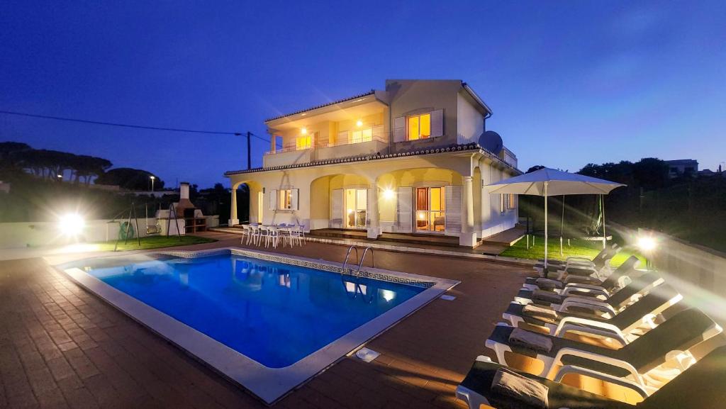 a villa with a swimming pool at night at Lara Lima by Check-in Portugal in Albufeira