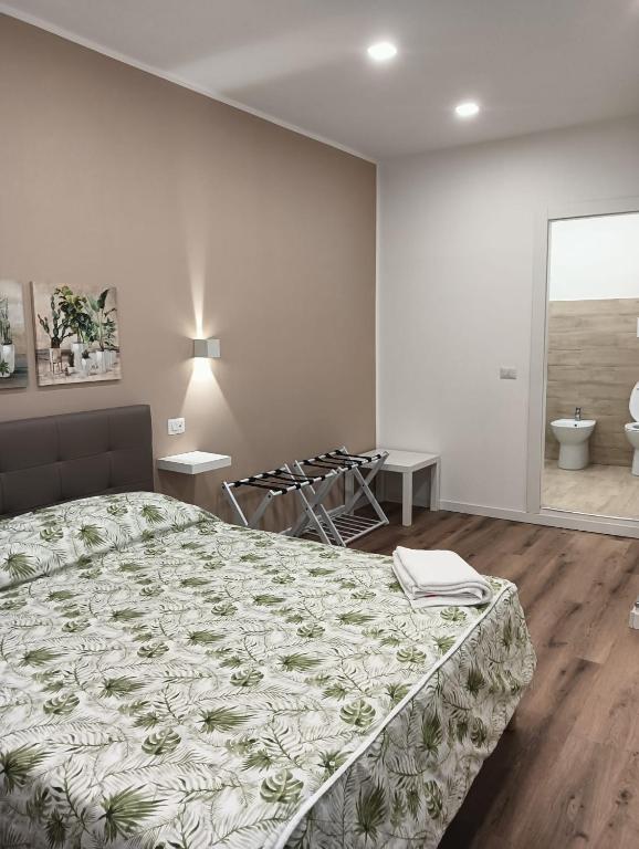 a bedroom with a bed and a bathroom at Al Carmine Rooms in Milazzo