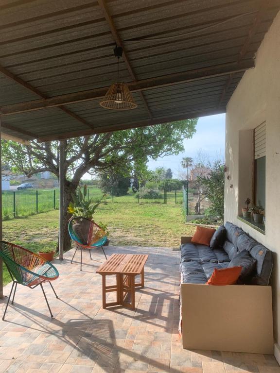 a patio with a couch and a table and chairs at Casita Flamingo in Deltebre