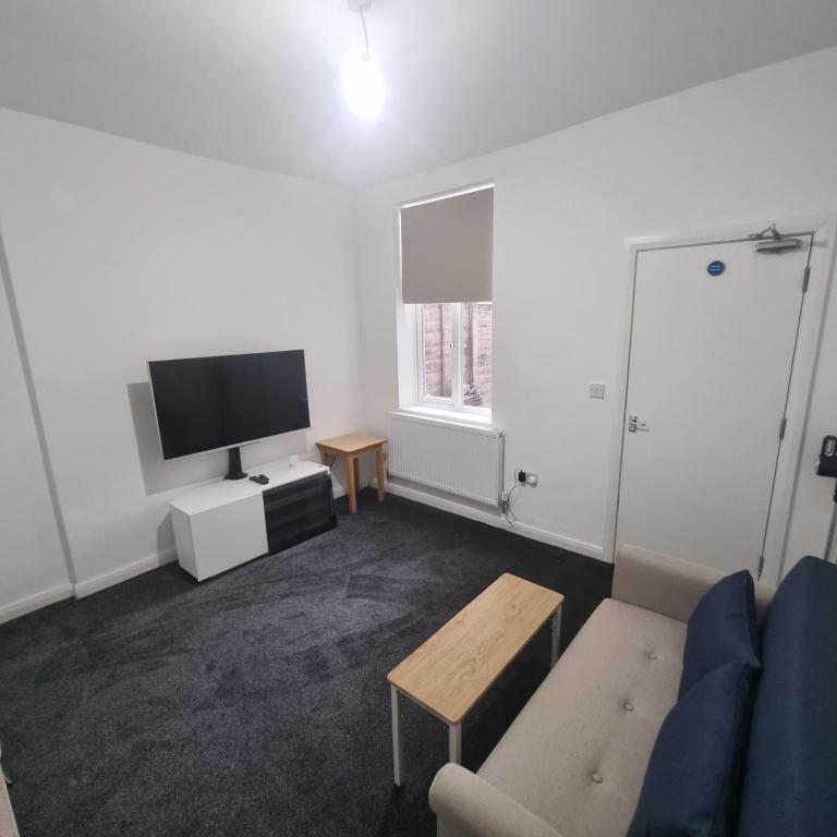 a living room with a couch and a tv at Near Manor Hospital Free Wifi in Walsall