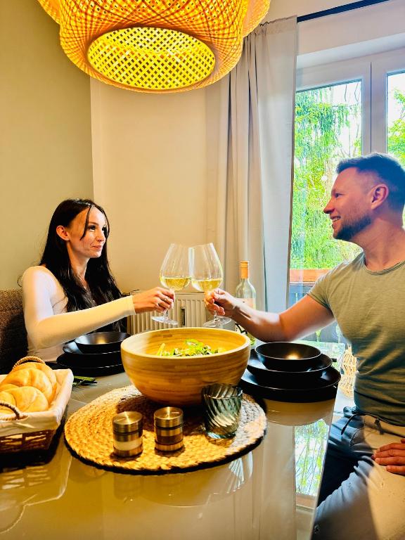 a man and a woman standing at a table with wine glasses at Joes cozy Apartment in Payerbach