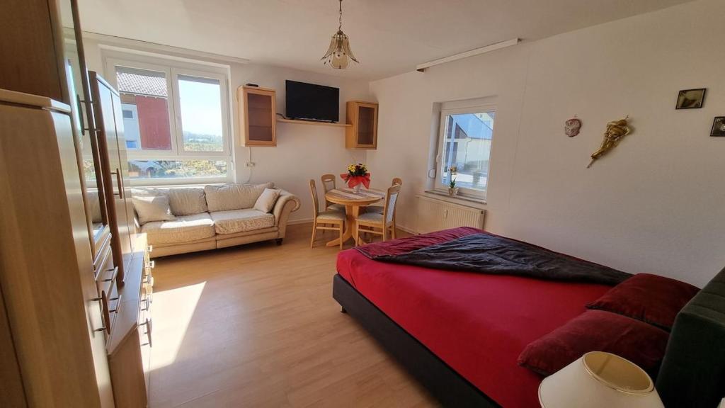 a bedroom with a bed and a living room at Fewo Linda - Gemütliche Ferienwohnung in direkter Bodenseenähe in Kressbronn am Bodensee