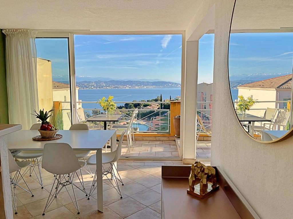 - une salle à manger avec une table et une vue sur l'eau dans l'établissement Superb T3 with terrace and sea view, à Théoule-sur-Mer