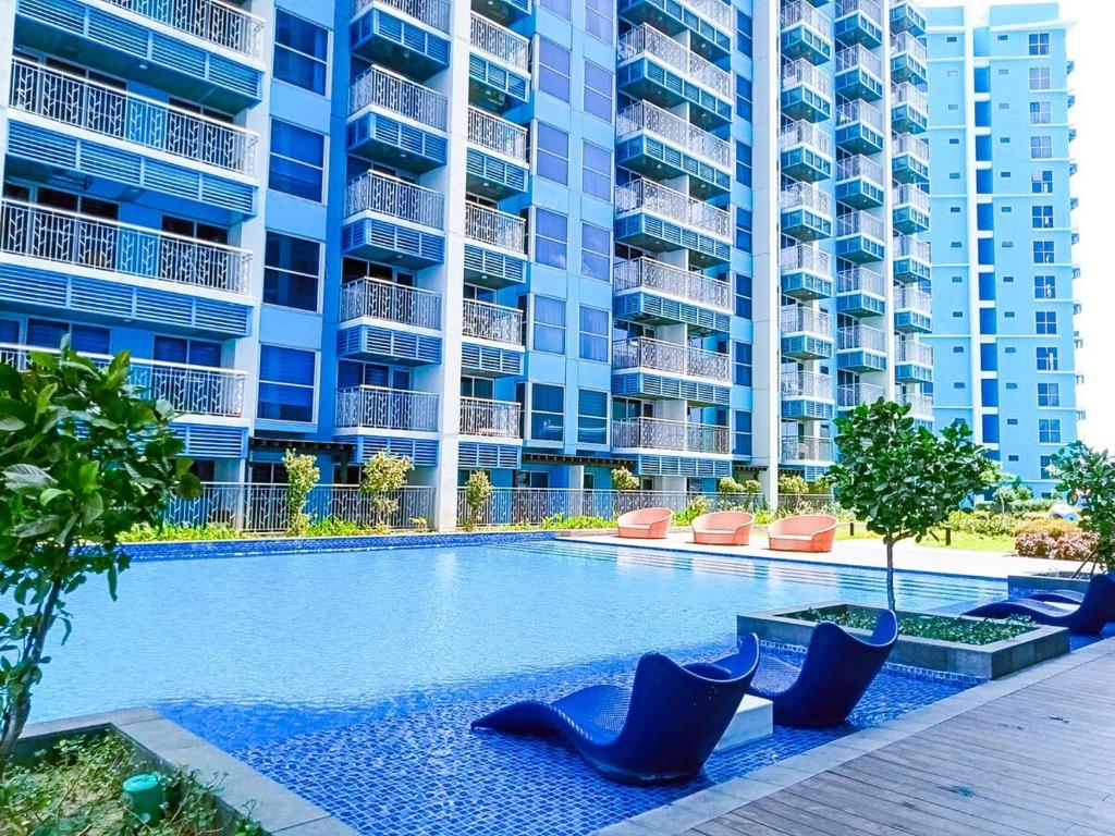 a swimming pool in front of a large apartment building at Cozy 1BR near Solaire, Okada, Mall of Asia in Manila
