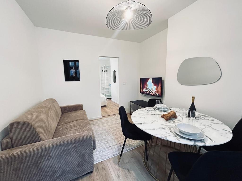 un salon avec un canapé et une table dans l'établissement 1 Clairmarais T2 cosy a 2 pas du centre-ville, à Reims