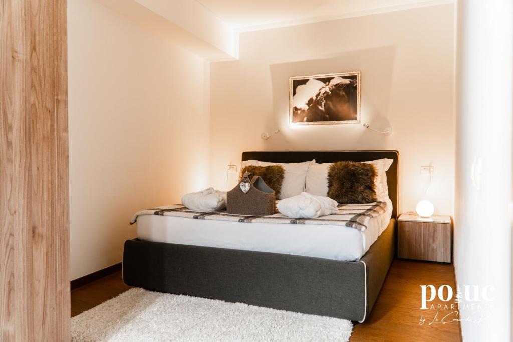 a bedroom with a bed with pillows on it at Rêve Blanc - Poluc Apartments bilocale in Champoluc