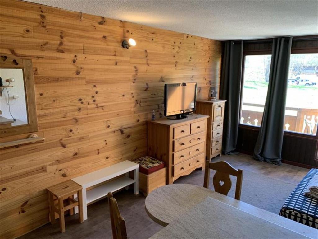 une pièce avec un mur en bois avec une télévision sur une commode dans l'établissement Plein Sud N2007 - ST4, à Les Deux Alpes