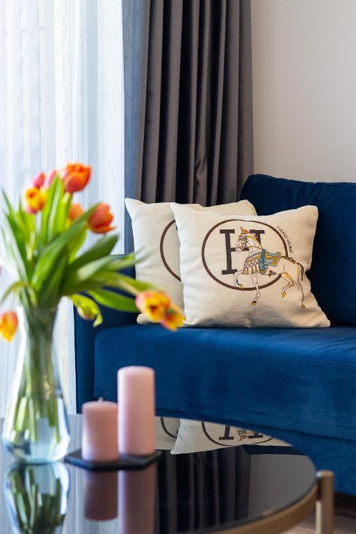a blue couch with a pillow with a horse on it at Azur Pearl by RV Apartments in Saints Constantine and Helena