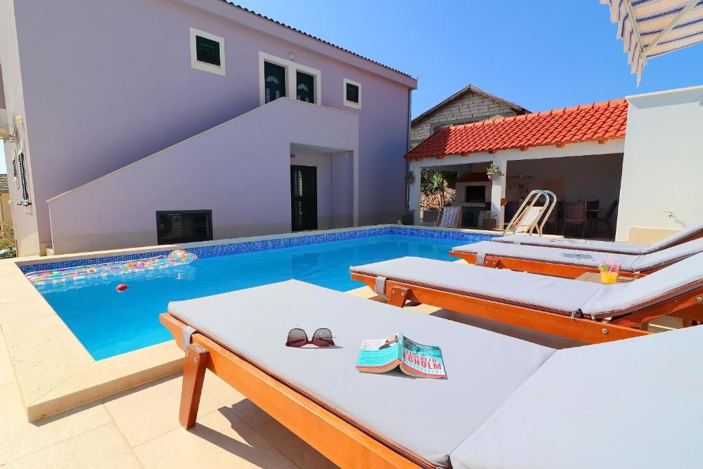 a villa with a swimming pool and a house at Villa Lavanda Korčula in Zavalatica