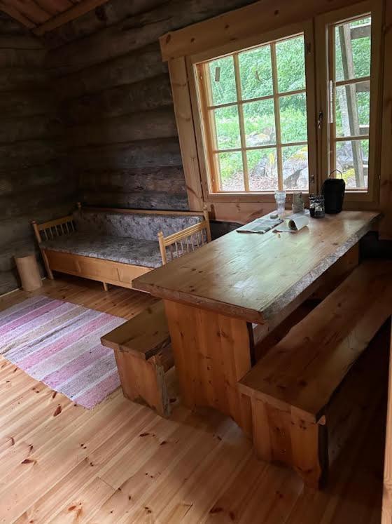 a room with a wooden table and bench in a cabin at Nivan Majoitus in Joensuu