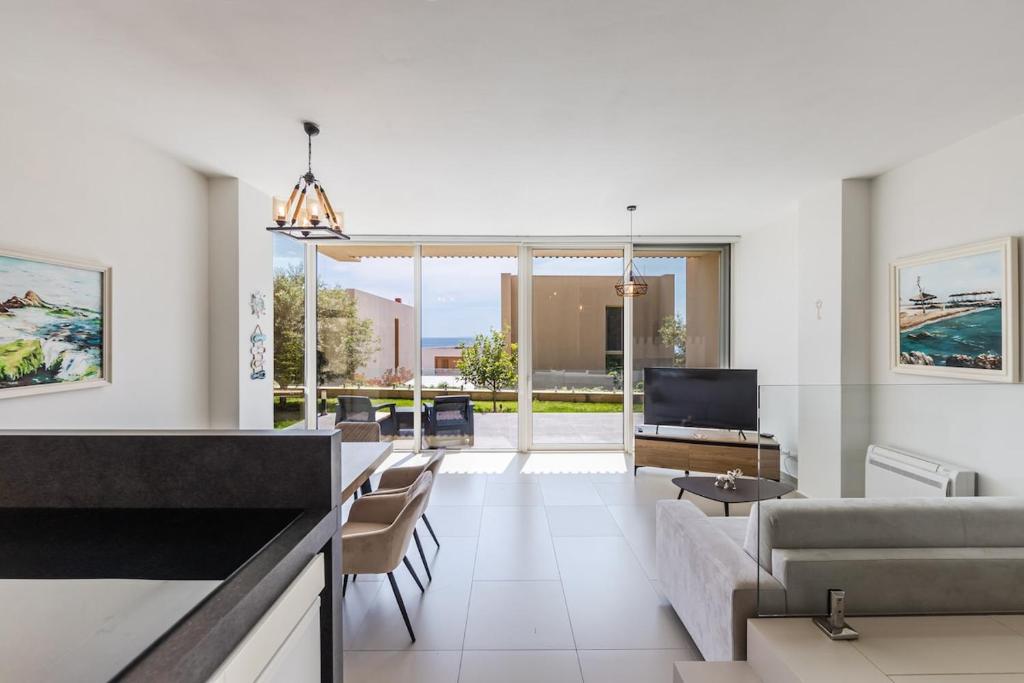 a living room with a couch and a tv at The Ionian Villa Green Coast in Himare