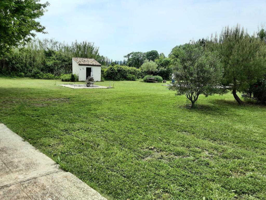 un grand champ herbeux avec un petit bâtiment au loin dans l'établissement M'as de l espine, à Eygalières