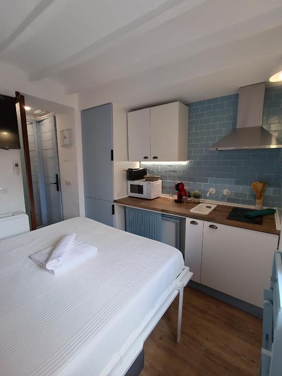 a kitchen with a white bed in a room at Bobal - Harbor's Light in Villajoyosa
