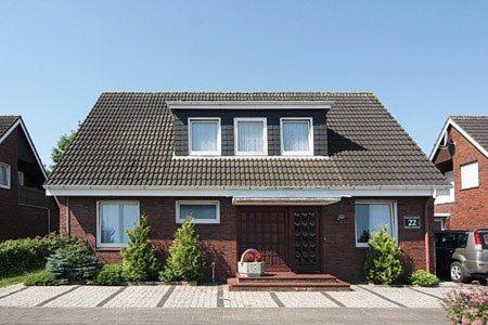 a brown house with a brown roof at Ferienwohnungen Reinders Lammertshörn 22 in Bensersiel