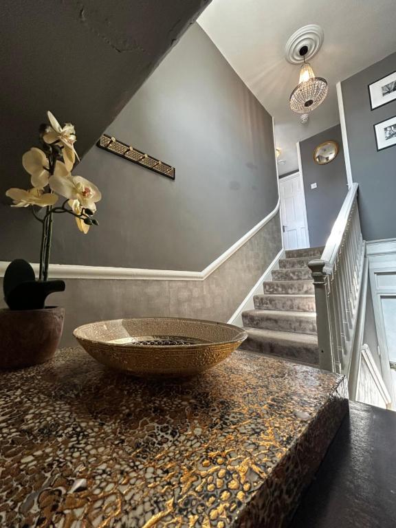 a room with a counter with a bowl on a table at Stylish City Centre Apartment in Bath