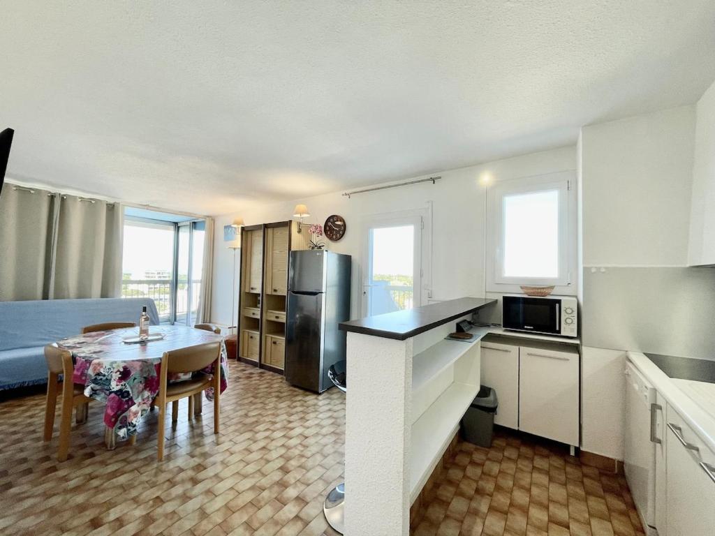 une cuisine et une salle à manger avec une table et une chambre dans l'établissement Appart T3 - 200 m plage - Dernier étage vue mer et camargue, à La Grande Motte