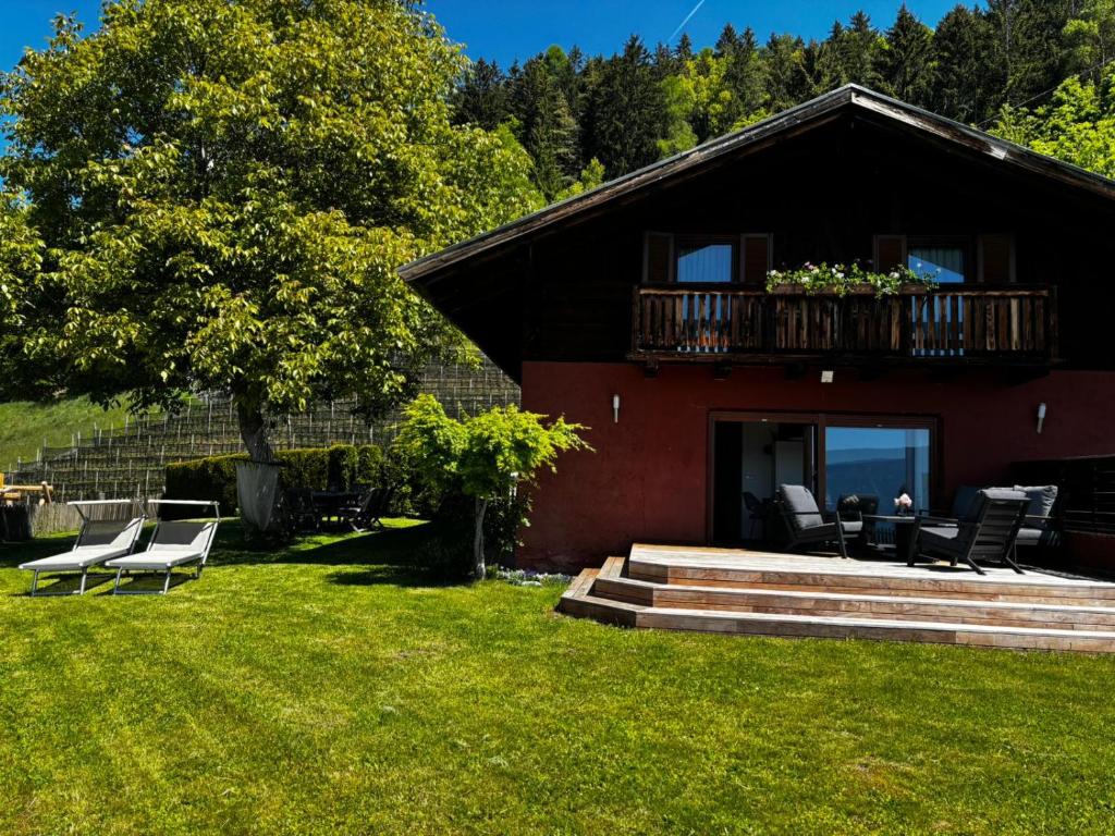 a house with a deck and chairs on the grass at Bergchalet Platzl in Verano