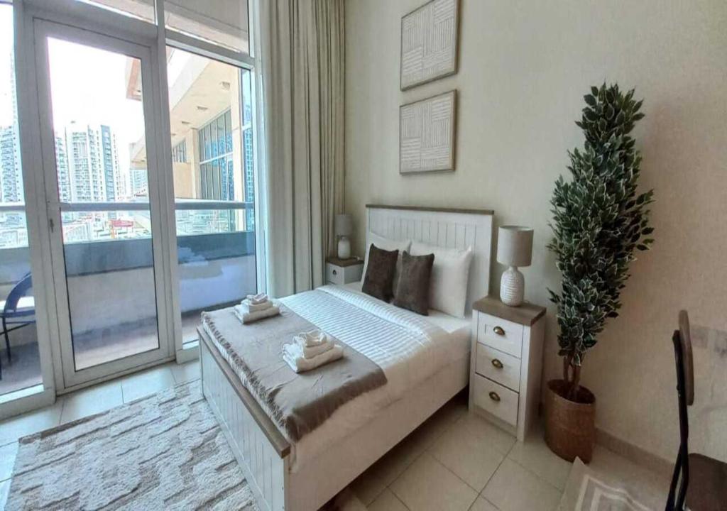 a bedroom with a bed and a large window at Bay Square studio Bay view in Dubai