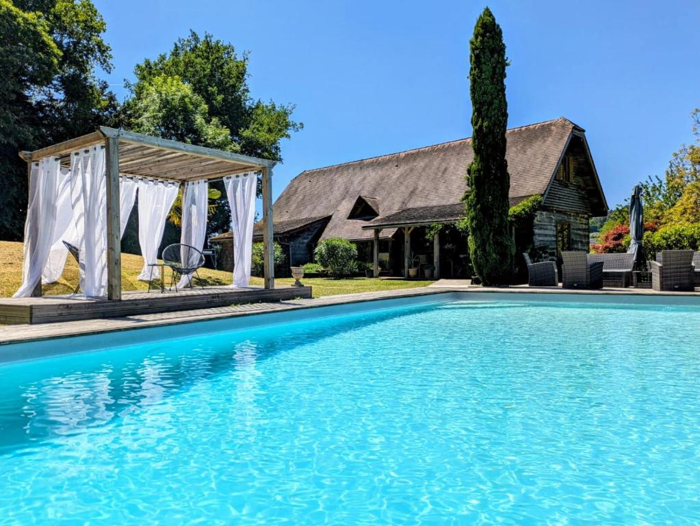 - une piscine en face d'une maison avec un kiosque dans l'établissement L'Isba, à Sarlat-la-Canéda