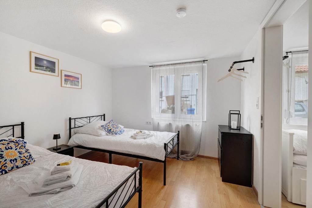 una piccola stanza con due letti e una finestra di M B Homes Schlatt Fewo 1 a Hechingen