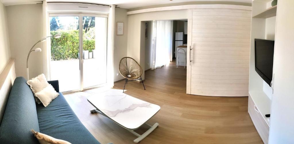 un salon avec un canapé bleu et une télévision dans l'établissement Coudoufamily, à Six-Fours-les-Plages