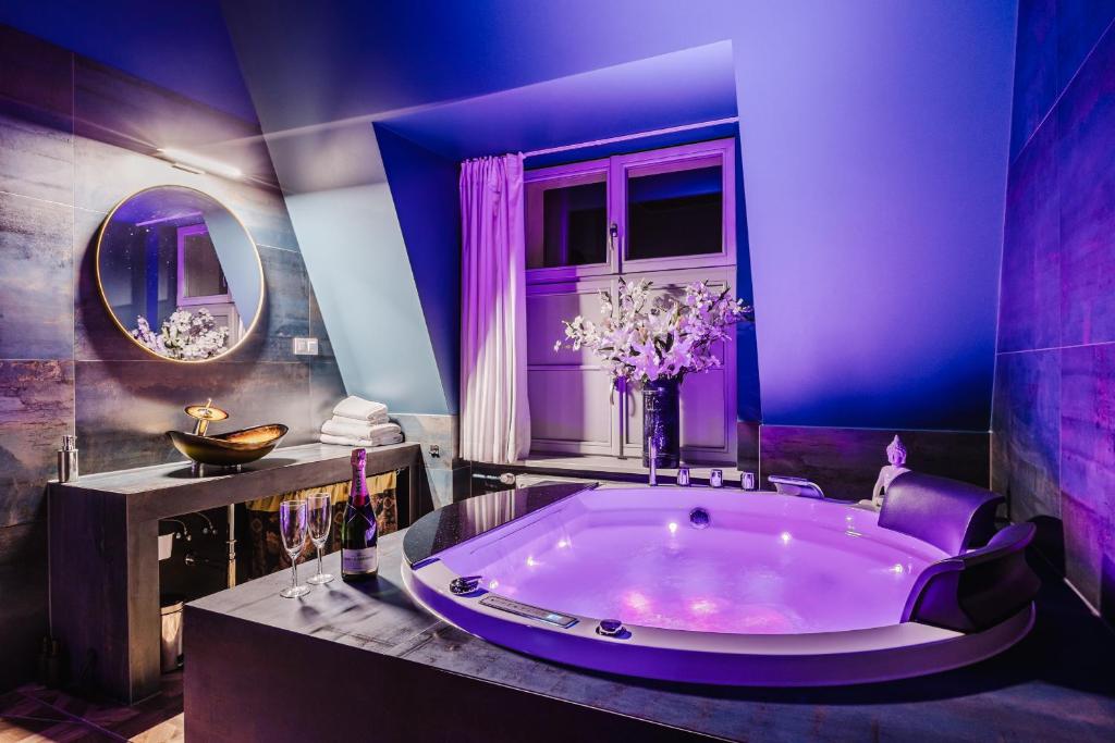 a large purple bathroom with a large tub at Blue House SPA & JACUZZI Poznań in Poznań