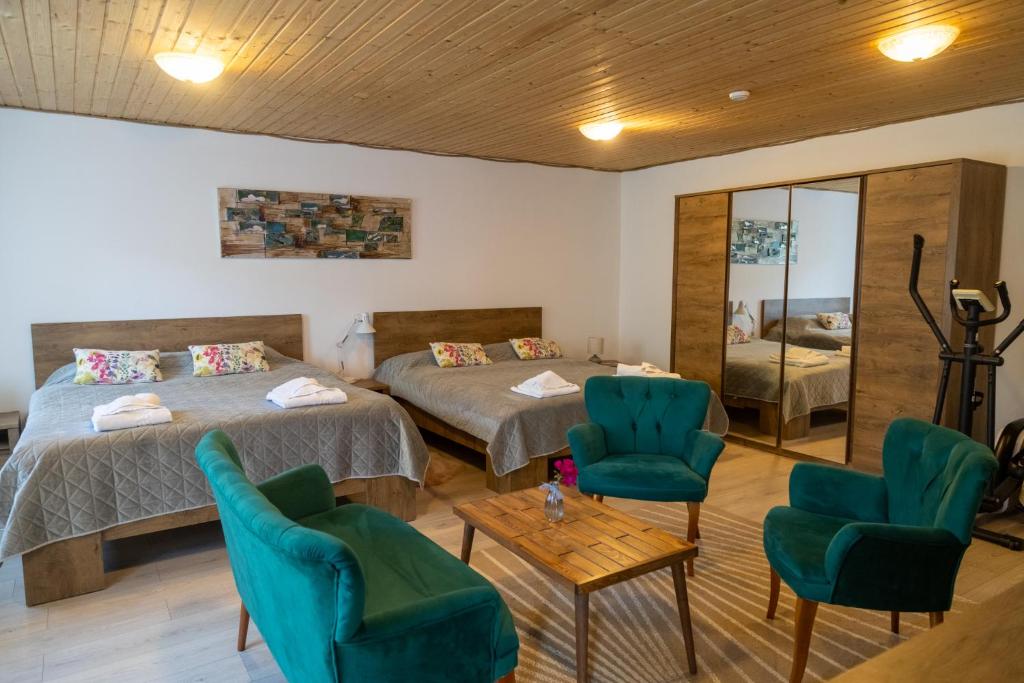 een kamer met 2 bedden en stoelen en een spiegel bij Casa Anastasia in Murighiol