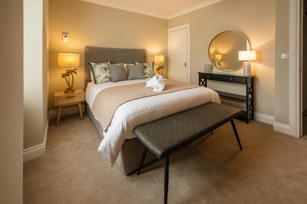 a bedroom with a large bed and a mirror at Stirling Townhouse Apartment Btm in Stirling