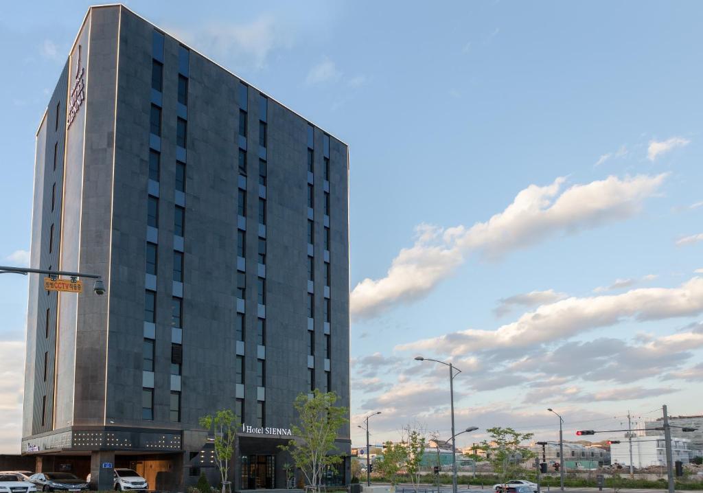 d'un grand bâtiment gris avec un panneau. dans l'établissement Hotel Sienna, à Paju