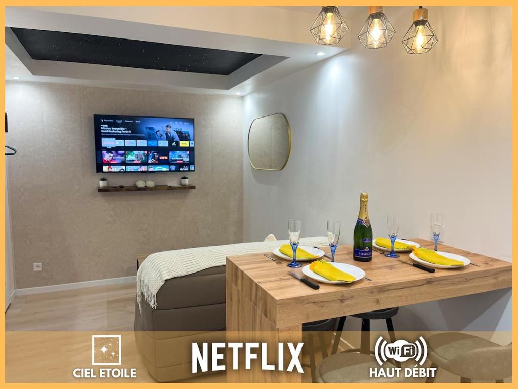 Cette chambre dispose d'une table et d'une télévision murale. dans l'établissement F2 ciel étoilé, au Havre