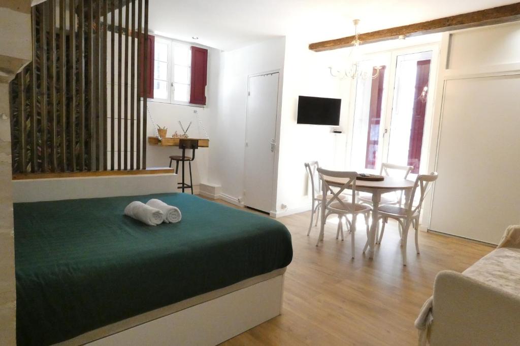 une chambre avec un lit, une table et des chaises dans l'établissement petit chateau rouge - Hypercentre - rénové, à Nantes