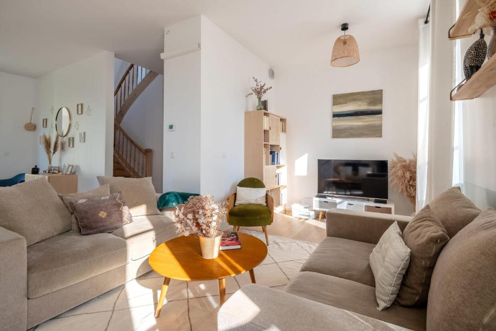 un salon avec un canapé et une table dans l'établissement Villa Mont d'or - Welkeys, à Champagne-au-Mont-dʼOr