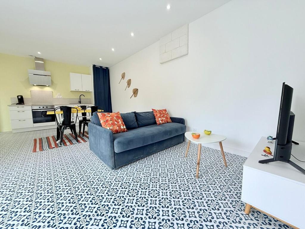 un salon avec un canapé bleu et une télévision dans l'établissement 1753-1 L'atelier du gabier, à Rochefort