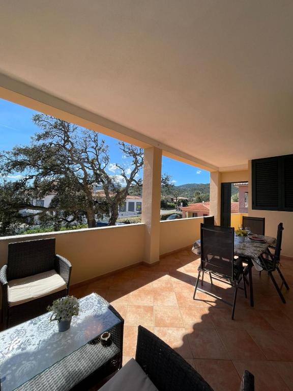 a living room with a table and chairs and a large window at Appartamento Gallospot in San Teodoro