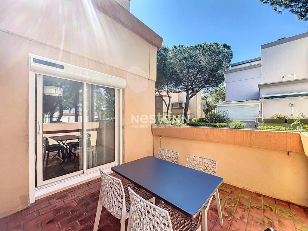 un patio avec une table et des chaises sur un balcon dans l'établissement 3122-T2 à 250m de la plage avec terrasse, et garage, à Argelès-sur-Mer