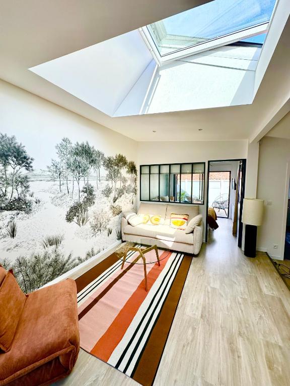 - une lucarne dans le salon doté d'un canapé dans l'établissement Charmante maison à 150 m de la plage, à Lège-Cap-Ferret